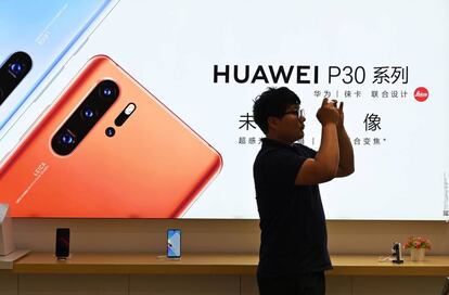 Un hombre prueba un teléfono de Huawei en una tienda de Shanghái