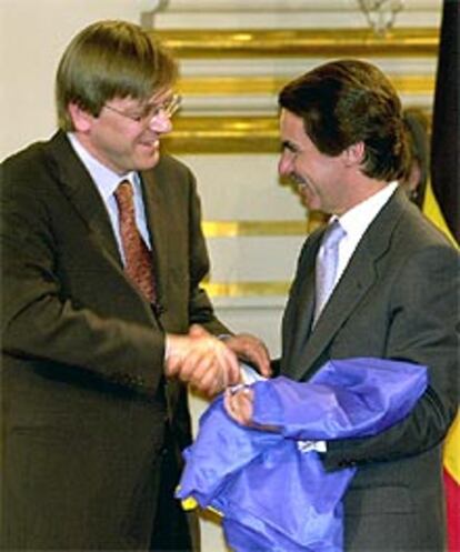 El presidente José María Aznar recibe de su homólogo belga, Guy Verhofstadt, la bandera de la UE.