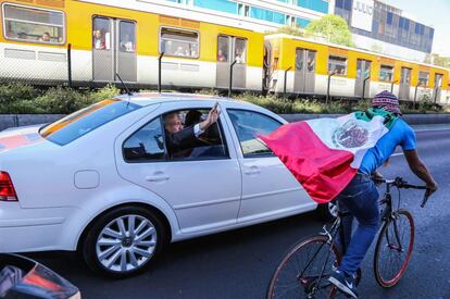 Un ciclista se acerca al automóvil de López Obrador.