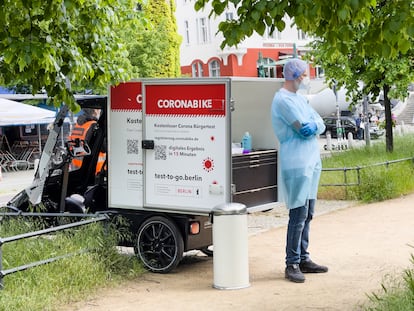 Un sanitario ante su laboratorio-bicicleta para hacer test rápidos de covid en un parque de Berlín.