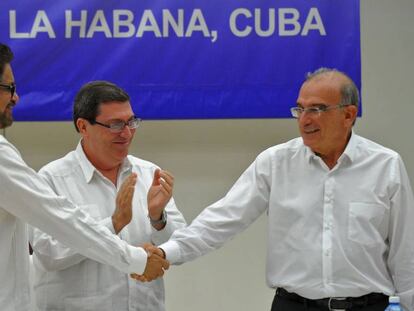 Iván Márquez and De la Calle shake hands in front of Cuban foreign minister Bruno Rodríguez.