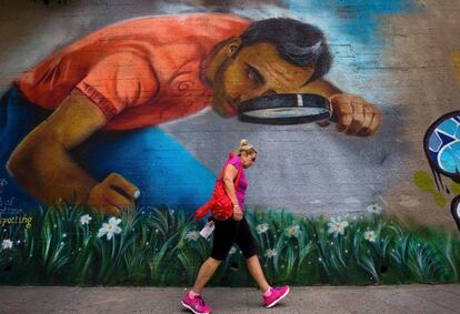 Una mujer pasa delante de un grafiti en Beirut (Líbano).