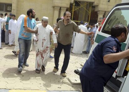 25 personas han muerto por el atentado cometido este viernes contra una mezquita chií en la ciudad de Kuwait y reivindicado por el grupo terrorista suní Estado Islámico. En la imagen, un hombre herido es trasladado al hospital tras el ataque.