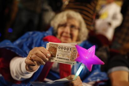 Una mujer muestra varios décimos del 00001 en el Teatro Real de Madrid, durante el sorteo extraordinario de Navidad de la Lotería Nacional, el 22 de diciembre de 2016.