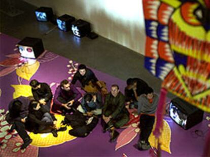 Artistas participantes, con el director del EACC, sentados sobre una de las instalaciones de <i>Asianvibe.</i>