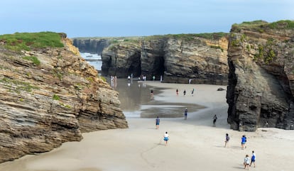 Decenas de turistas recorren la famosa playa de Las Catedrales, en la provincia de Lugo.