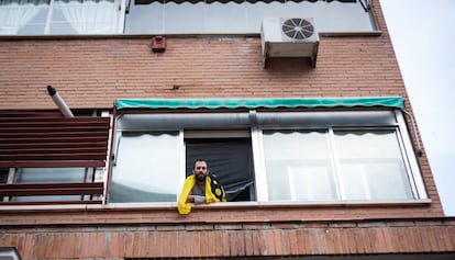 Mientras los monumentos están vacíos, la mayor parte de la gente se queda en su casa. Un hombre se asoma por su ventana en plenas restricciones por el virus. Imagen tomada el 15 de marzo en Madrid.