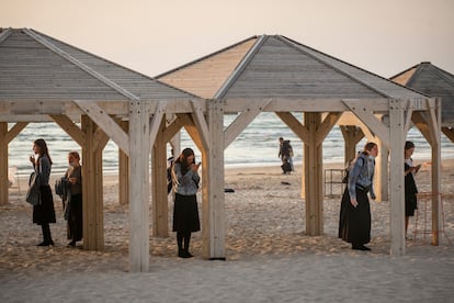 Jóvenes religiosas rezando bajo unas casetas en una playa de Tel Aviv. 