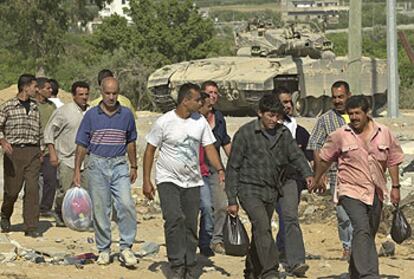 Un grupo de palestinos cruzaba ayer la frontera de Erez, en Gaza, tras una jornada de trabajo en Israel.