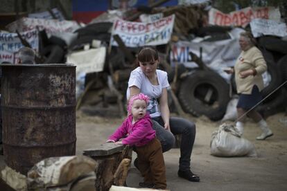 Una madre juega con su hija delante de unas barricadas en Slovyansk (Ucrania), 19 de abril 2014.