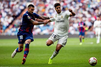 Asensio pelea un balón con el centrocampista uruguayo del Levante Erick Cabaco.