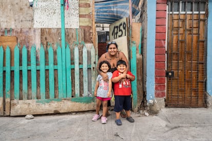 Yessenia Reyes sonríe en la puerta de su vivienda con sus dos hijos pequeños, Luis y Aisa Paez, de 5 y 6 años. Yessenia está preocupada porque no ha recibido ninguna llamada del hospital, pese a que logró hace dos años que sus hijos entraran dentro del grupo de niños a los que se les harían exámenes oficiales de presencia de polimetales. Ni en persona ni por teléfono le explican qué ha pasado, y su familia carece de los recursos suficientes para examinar a sus tres hijos en una clínica privada.