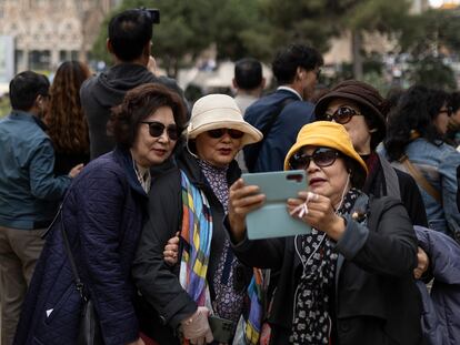 Un grupo de mujeres se toman una fotografía ante la Sagrada Familia en Barcelona.