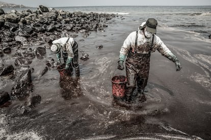 Trabajadores intentan limpiar el petróleo en la playa en Ventanilla, al norte de Lima, en diciembre de 2022.