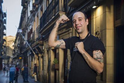 Edorta Lamo, dueño del local A fuego negro, muestra la gilda tatuada en su brazo derecho.