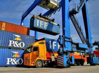 Una grúa carga contenedores en un camión, en la terminal de contenedores del Puerto de Bilbao.