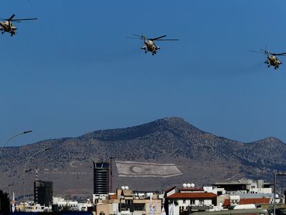 Helicópteros de las fuerzas aéreas de Chipre vuelan sobre la Nicosia dividida el pasado 1 de octubre durante un desfile que conmemora la independencia de la antigua colonia británica. Al fondo, en la montaña, se ven las banderas de Turquía y de la RTNC.