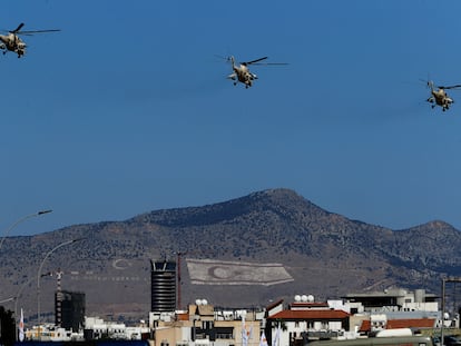 Helicópteros de las fuerzas aéreas de Chipre vuelan sobre la Nicosia dividida el pasado 1 de octubre durante un desfile que conmemora la independencia de la antigua colonia británica. Al fondo, en la montaña, se ven las banderas de Turquía y de la RTNC.