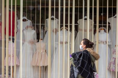 Una mujer pasa delante de una tienda cerrada en Zaragoza.