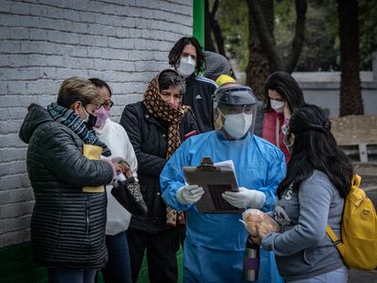 Personal sanitario informa sobre el registro para recibir vacunas contra la covid-19, en el centro de salud Dr. José Ma. Rodríguez, en Ciudad de México, el 23 de diciembre.