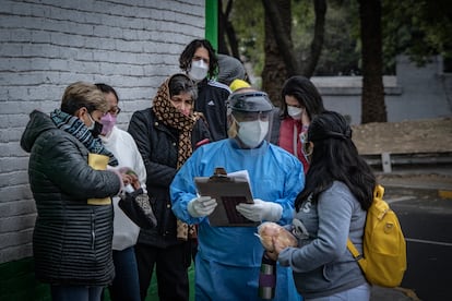 Personal sanitario informa sobre el registro para recibir vacunas contra la covid-19, en el centro de salud Dr. José Ma. Rodríguez, en Ciudad de México, el 23 de diciembre.