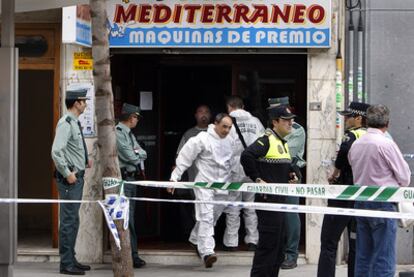 Agentes de la Policía Local y de la Guardia Civil, ayer, a la puerta del salón recreativo de Catarroja en el que fue hallada la mujer.