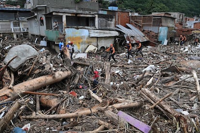 Equipos de rescate y familiares buscan entre los escombros de casas arrastradas por la inundación de un arroyo, en Tejerías.