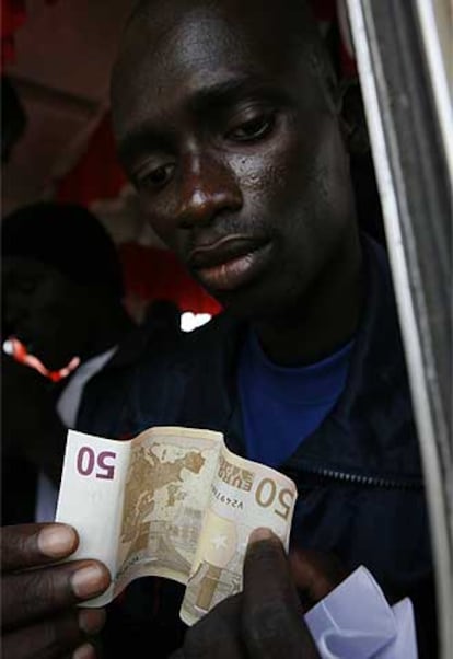 Un senegalés expulsado muestra el billete que le dieron en España.