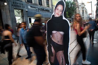 Una figura de papel con la imagen de la cantante sobre la calle Madero, que transeúntes caminan para llegar al concierto en el Zócalo.