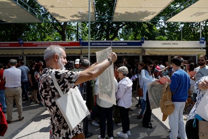 Uno de los ganadores de la yincana recoge un mapa de El Retiro, uno de los premios de la prueba. 