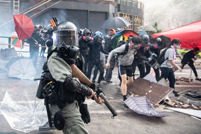 Um agente de polícia persegue os manifestantes na Universidade Politécnica de Hong Kong.