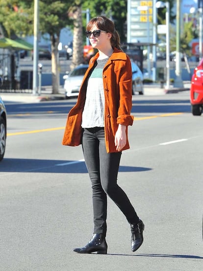 Pitillos grises, chaqueta anaranjada y botines negros planos. Así de sencilla vimos a Dakota Johnson paseando por Los Ángeles.