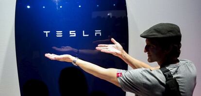 Un hombre muestra una de las superbaterías de Tesla.