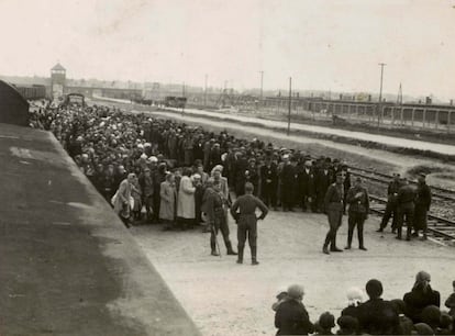 Deportados judeus esperando o processo de seleção. Ao fundo é possível ver a entrada de Birkenau, conhecida atualmente como “A porta do suplício”.