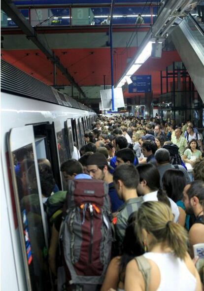 Usuarios del metro intentan acceder a uno de los trenes en una jornada en la que funciona a la mitad el servicio por la huelga, en Nuevos Ministerios