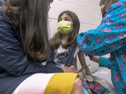 Alejandra Gerardo, de nove anos, olha para sua mãe enquanto é vacinada contra a covid-19 no hospital da Universidade de Duke, nos Estados Unidos. Alejandra e sua irmã gêmea, Marisol, são as primeiras crianças a receber a vacina da Pfizer nos EUA.