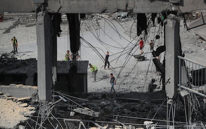 Varios palestinos inspeccionan los daños sufridos por un colegio de la ONU en la Franja de Gaza, tras sufrir un ataque por parte del ejército de Israel.