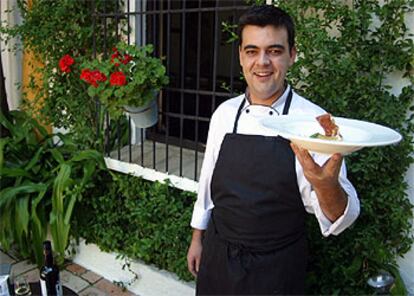 Juan Gutiérrez Moreno, jefe de cocina de Bodegas Campos, en el patio del restaurante. Abajo, ensalada de bacalao y naranja.