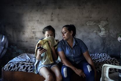 Miriam González le enseña un vídeo musical a su madre mientras comparten la mañana del sábado. Viven en el Bañado Sur, una zona a las afueras de la capital donde habitan más de 120.000 personas, la mayor parte de escasos recursos, olvidada por el Estado y estigmatizada por los medios del país.