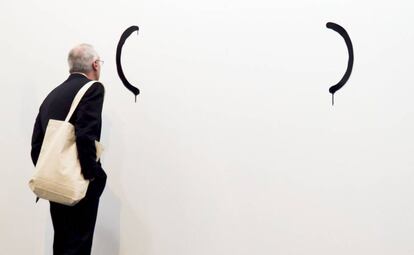 Un hombre observa una obra de la Galeria Luis Adelantado.