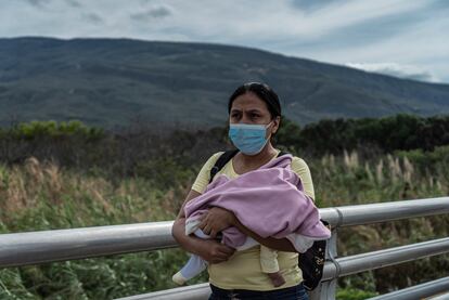 Una mujer cruza con un bebé desde Venezuela a Colombia.