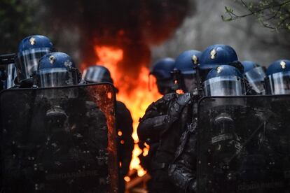 Policías antidisturbios cerca de una barricada en llamas durante el desalojo de un campamento de activistas en Notre Dame des Landes (Francia).