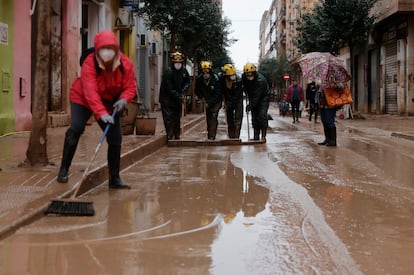 Voluntarios y bomberos trabajan en la limpieza de calles en Catarroja (Valencia) este miércoles.