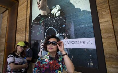 Una mujer frente a una tienda con una pintada prodemocracia el miércoles en Hong Kong.