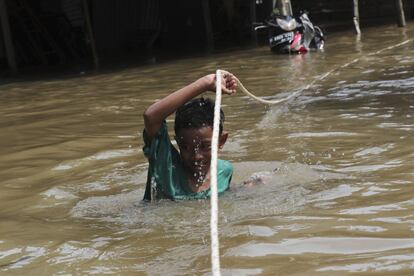 La capital, con una población de alrededor de 30 millones, suele verse afectada por inundaciones durante la temporada de lluvias, que comenzó a finales de noviembre. En la imagen, un niño se desplaza agarrado a un cuerda por una calle anegada de Yakarta.