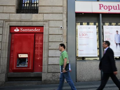 Dos viandantes pasan frente a una sucursal del Banco Santander, en Madrid.