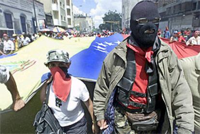 Dos partidarios enmascarados de Hugo Chávez, ayer durante la marcha a favor del presidente venezolano en Caracas.