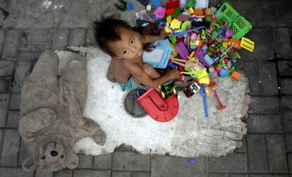 Un ni&ntilde;o sin hogar y sus juguetes recogidos por sus padres en las calles de Manila, Filipinas.