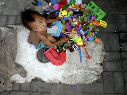 Un ni&ntilde;o sin hogar y sus juguetes recogidos por sus padres en las calles de Manila, Filipinas.