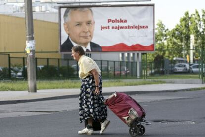 Una mujer pasa ante un cartel de la campaña electoral de Jaroslaw Kaczynski en una calle de Varsovia.